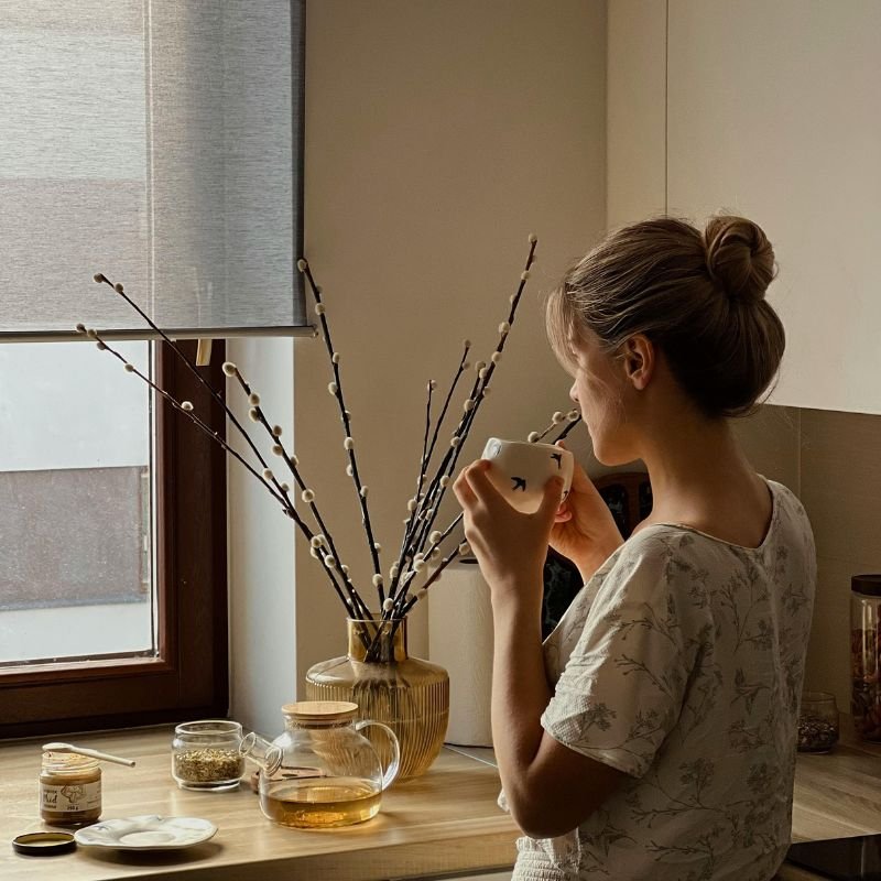 mujer creando un ritual de autocuidado con infusión en casa ambiente relajante